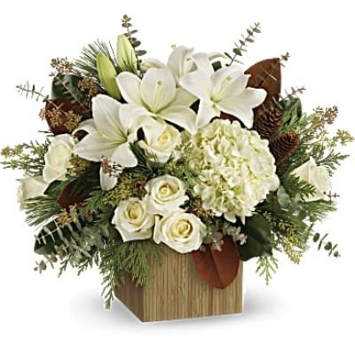 Give the gift of modern winter-white style with this breathtaking bouquet, hand-arranged in a wooden cube.
This winter bouquet includes white hydrangea, white roses, white asiatic lilies, magnolia leaves, seeded eucalyptus, spiral eucalyptus, flat cedar and white pine.